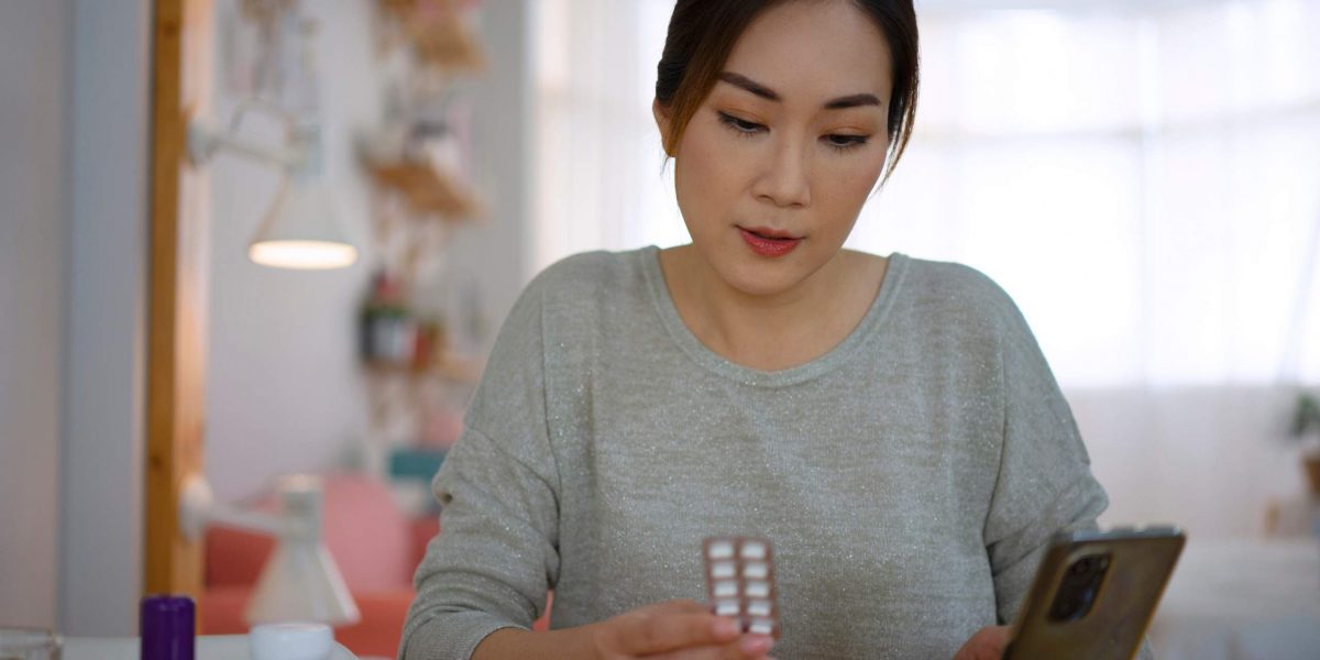 Paybackpunkte-Apotheke-Heilmittelwerbegesetz: Frau mit Blister und Smartphone