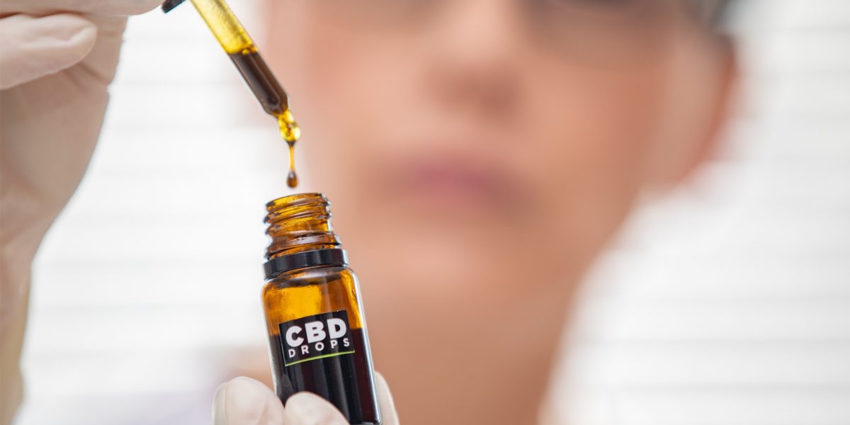 CBD-ÖL-Dropper tropft in das CBD-Öl-Fläschchen.