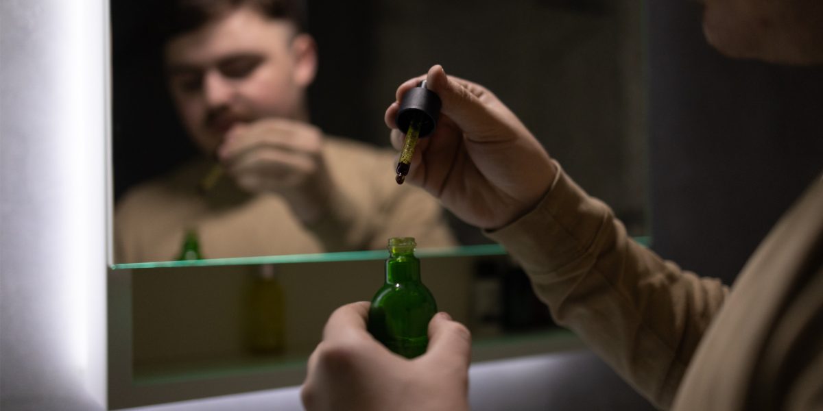 Mann im Bad überlegt, ob er CBD-Öl morgens oder abends nehmen soll