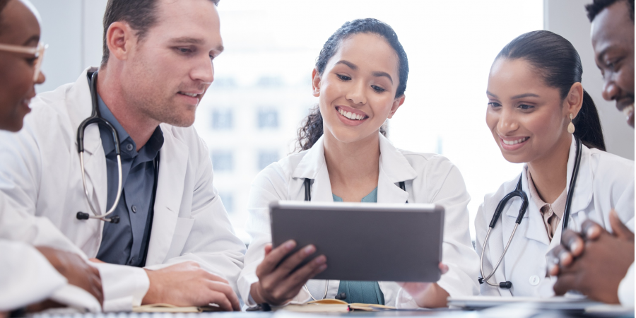cropped-shot-of-a-group-of-young-doctors-looking-at-a-tablet-during-a-picture-id1356724774