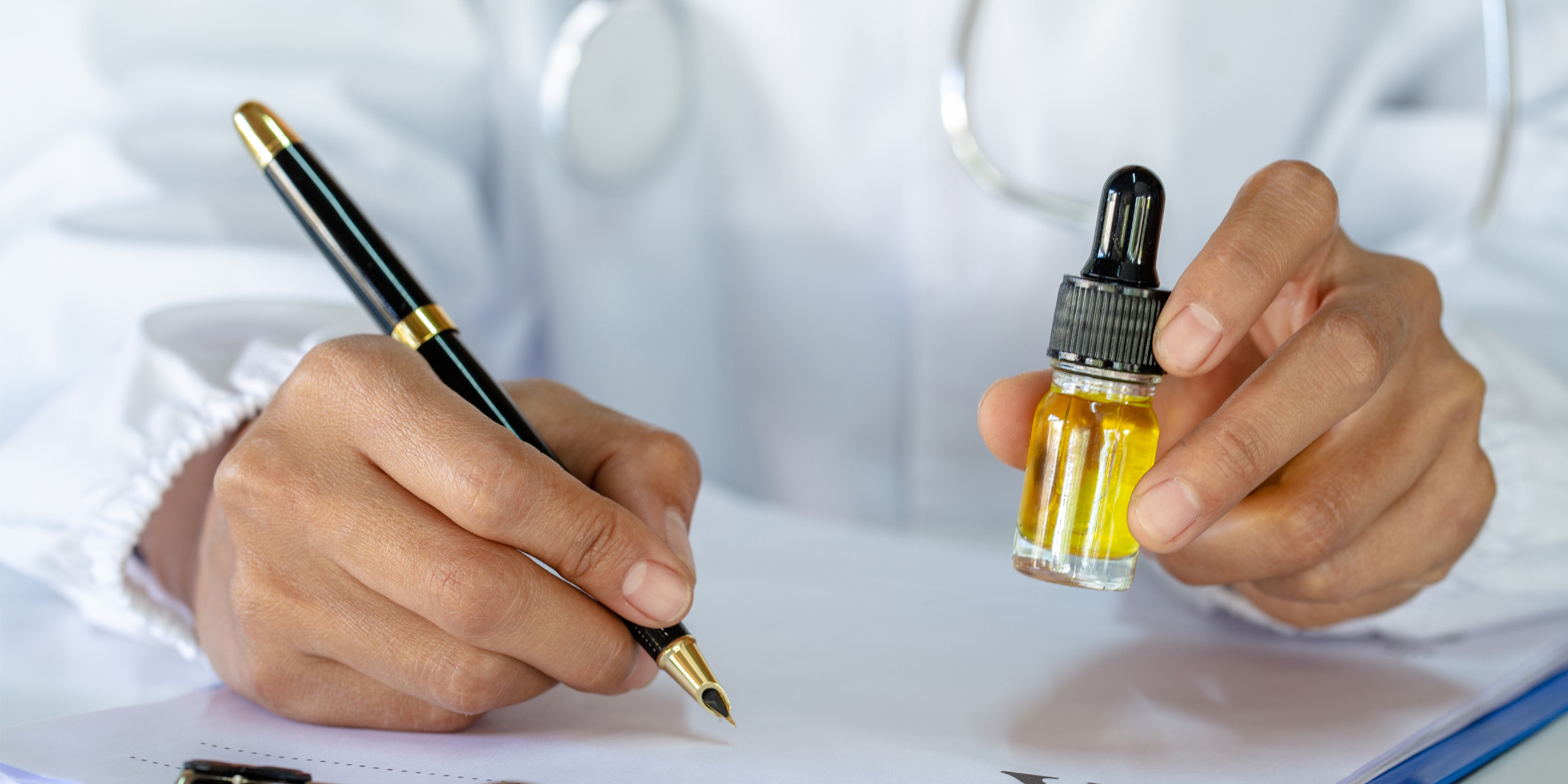 arzt hält cbd-öl in der Hand und schreibt etwas auf